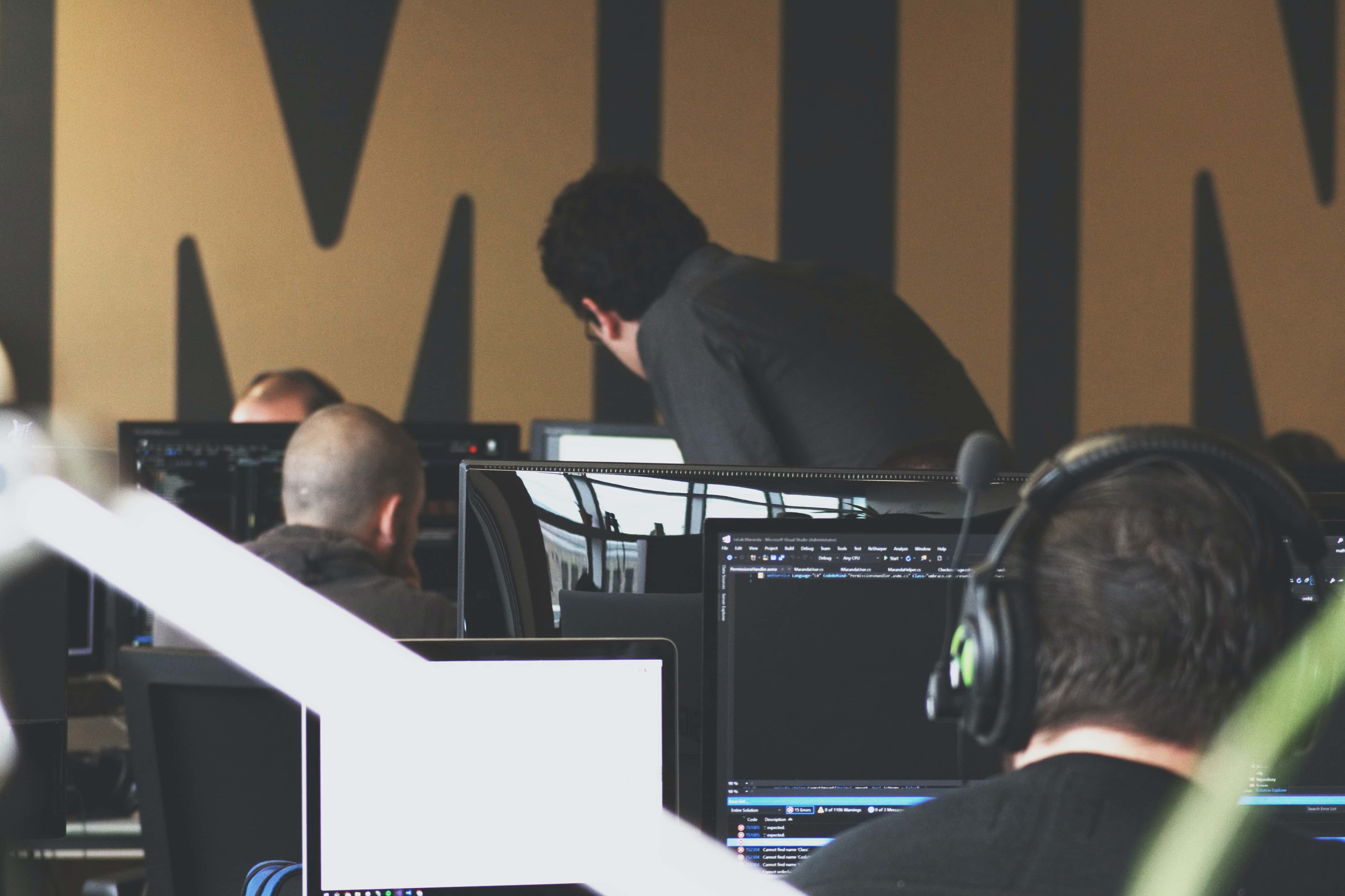A photo of several people looking at their computer screens in a workplace setting.